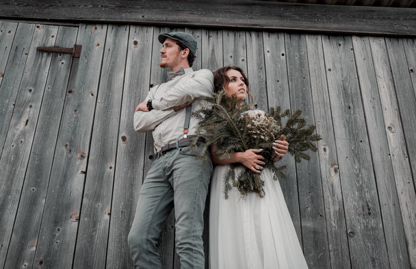 Standing couple in the fields at mountain sunset. Modern couple and ideas for the ceremony. Wedding in American style. - Foto, imagen