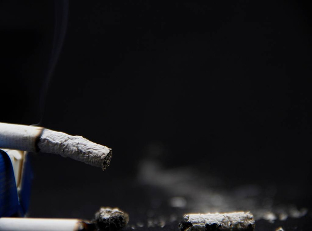 basura del cigarrillo sobre un fondo negro
 - Foto, imagen