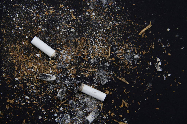 basura del cigarrillo sobre un fondo negro
 - Foto, Imagen