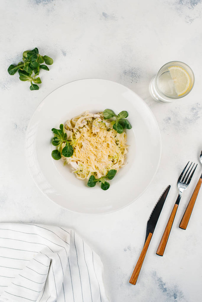 Pâtes aux herbes et fromage parmesan dans une assiette blanche
 - Photo, image