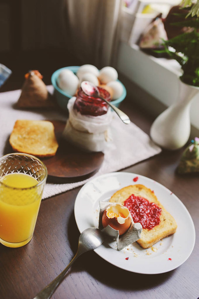 country cottage kitchen with breakfast on wooden table. Toast with jam, farm eggs and coffee - 写真・画像