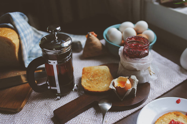 country cottage kitchen with breakfast on wooden table. Toast with jam, farm eggs and coffee - Fotoğraf, Görsel