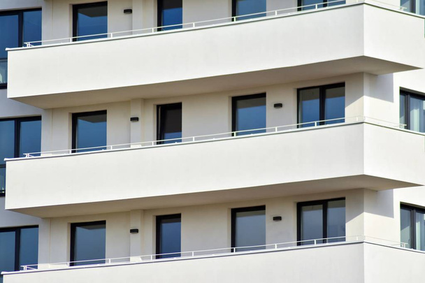 Сучасна біла будівля з балконом на блакитному небі
 - Фото, зображення