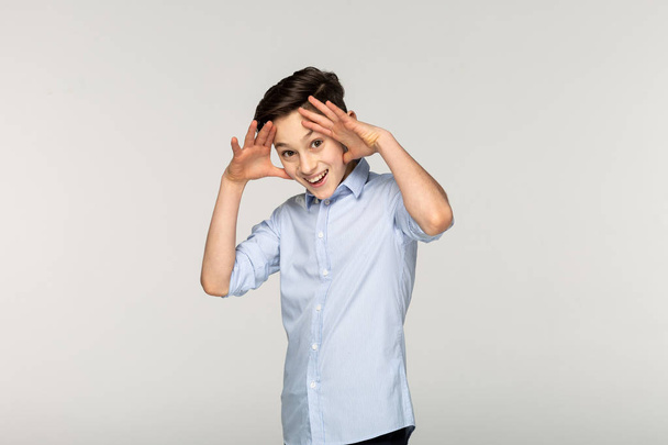 Close up portrait of young boy in blue shirt. Face expressions - Fotó, kép