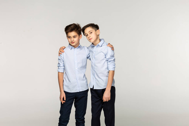 Two attractive boys teenagers in blue shirts - Fotoğraf, Görsel
