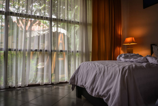 Балі, Індонезія - 14 січня 2018: Готельний номер з ліжком і висячі плетеними стільцями за вікном на території Discovery Кандідаса котеджів і вілли готелю, Балі, Індонезія - Фото, зображення
