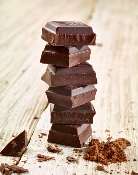 Крупним планом шоколадні шматочки на дерев'яному фоні
 - Фото, зображення
