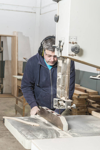 Worker man concept. Male carpenter working in his carpentry workshop. - Foto, Imagen