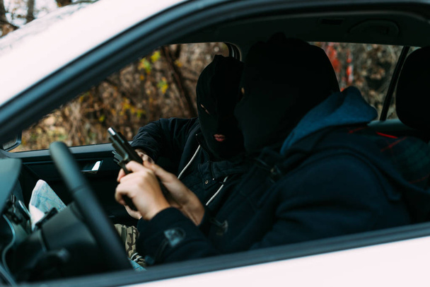rapinatori di banche che indossano la maschera pronti a fare la loro prossima rapina, controllando e caricando le armi. - Foto, immagini