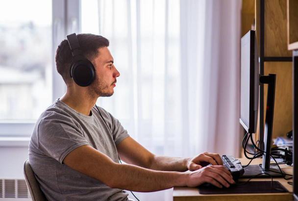 Αρσενικό ελεύθερος επαγγελματίας που εργάζεται από το σπίτι στον υπολογιστή - Φωτογραφία, εικόνα