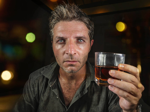 young messy and wasted man drunk at night club or bar drinking whiskey glass looking hammered celebrating party or suffering alcoholism problem and alcohol addiction - Fotoğraf, Görsel
