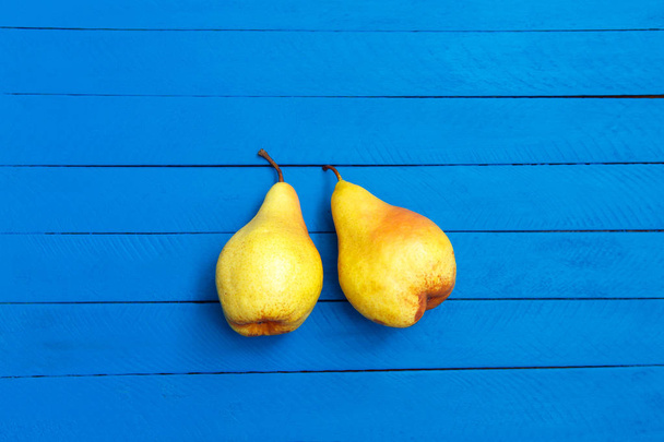 Pear decoration stock images. Yellow pear on blue background. Pear home decor. Yellow decorative pear - Photo, Image