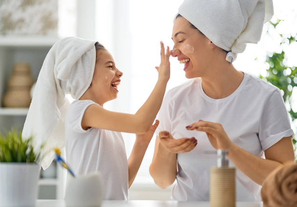 Happy family! Mother and daughter child girl are caring for skin in the bathroom. - Fotoğraf, Görsel