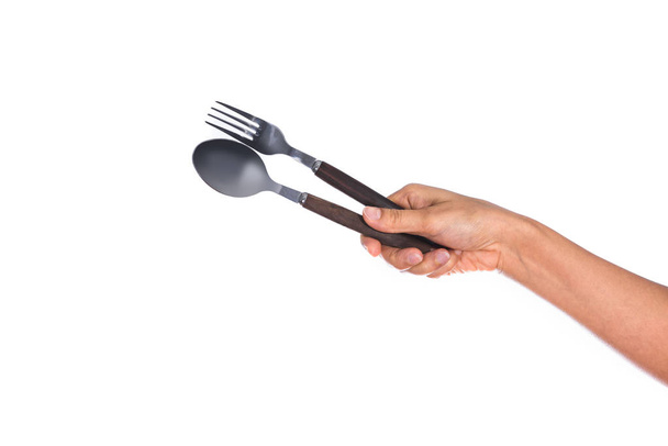 Tenedor y cuchara sostenidos por las manos de una mujer aislados sobre fondo blanco
 - Foto, imagen