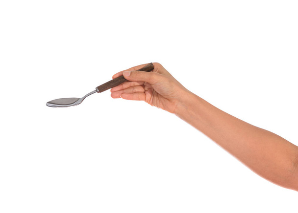 Woman hand holding an empty spoon, composition isolated over on the white background with clipping path - Фото, изображение