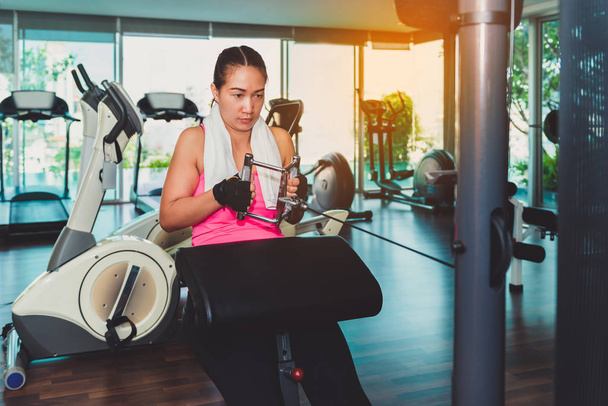 Woman at the gym working out on a Weight machine - Photo, image