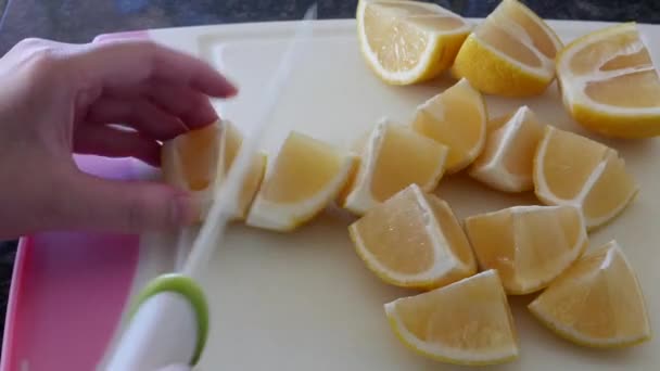Motion of woman using ceramic chef knife and cutting lemon on cutting board  - Imágenes, Vídeo