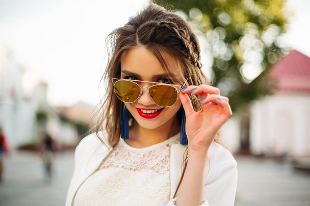 Pretty girl in sunglasses looking at camera. - 写真・画像