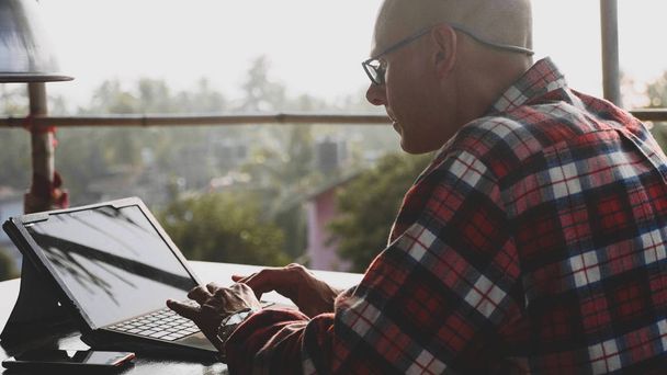 Красивий чоловік друкує на ноутбуці в зоні коворкінгу на відкритому повітрі
 - Фото, зображення