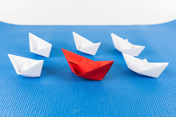 Führungskonzept mit rotem Papierschiff vor weißem und blauem Hintergrund - Foto, Bild
