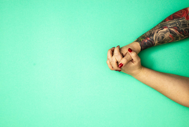 tattooed hands of a girl on green casino background with copy space ,  flat lay , top view - Fotó, kép