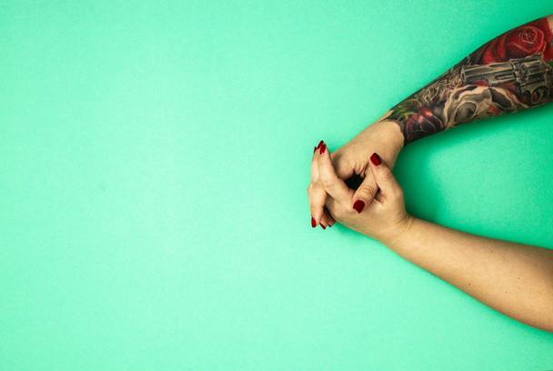 tätowierte Hände eines Mädchens auf grünem Casino-Hintergrund mit Kopierraum, flache Lage, Draufsicht - Foto, Bild