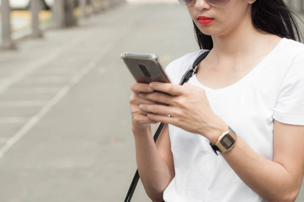 Eine junge Frau benutzt ein Smartphone - Foto, Bild