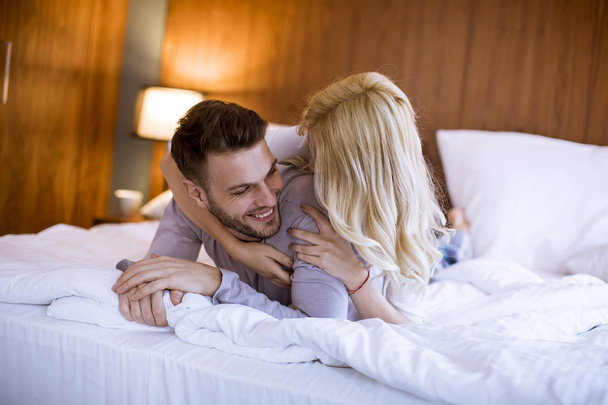 Romântico jovem casal apaixonado deitado na cama em casa juntos
 - Foto, Imagem