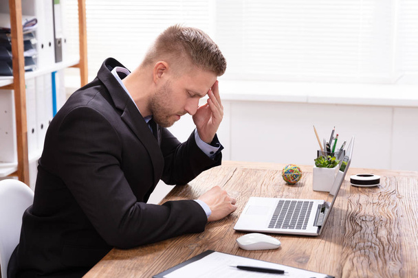 Young Man Suffering From Headache Working In Office - Photo, image