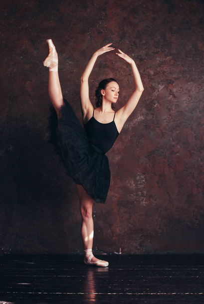 Balerína tanečnice baletu v krásné černé šaty tutu sukně pózuje v podkroví studio - Fotografie, Obrázek