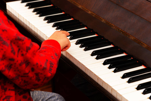 De jongen speelt ijverig de piano - Foto, afbeelding