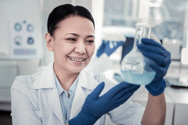 Smiling female scientist working with chemical liquids - Фото, зображення