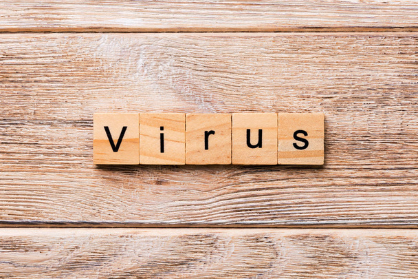 virus word written on wood block. virus text on wooden table for your desing, concept. - Photo, image