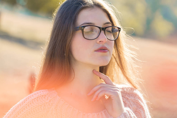 Portrait of pretty young woman in stylish knitted sweater standing on the golden autumn forest on sunny day, Time to relax and have some coffee - Foto, Imagen