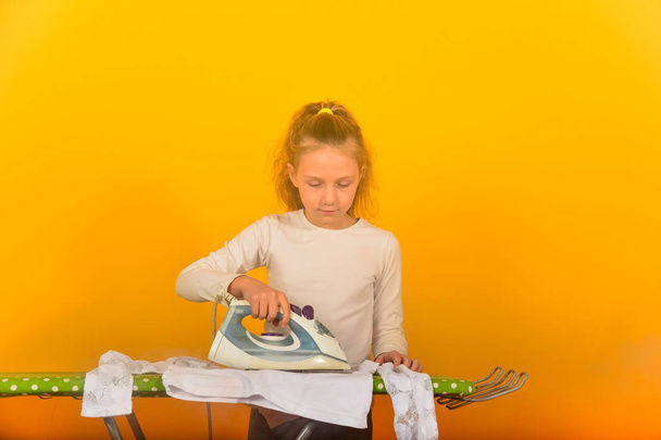 Девушка гладит бельё на гладильной доске
 - Фото, изображение