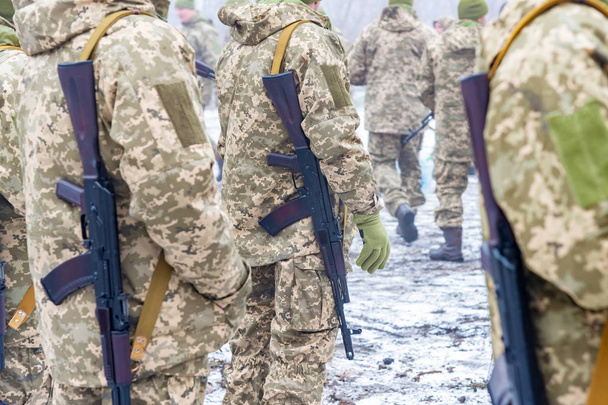 un destacamento de soldados con fusiles de asalto Kalashnikov están en formación para prepararse para la batalla y la ofensiva
. - Foto, Imagen