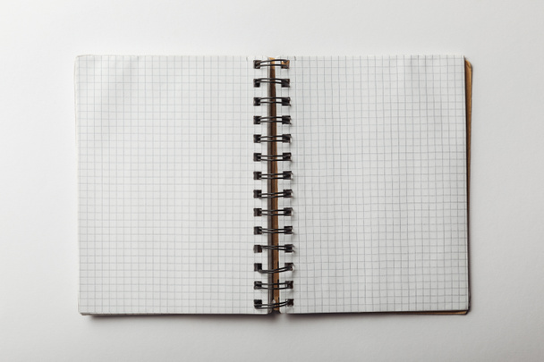 vista superior del cuaderno abierto con papeles cuadrados en blanco sobre fondo blanco
 - Foto, Imagen