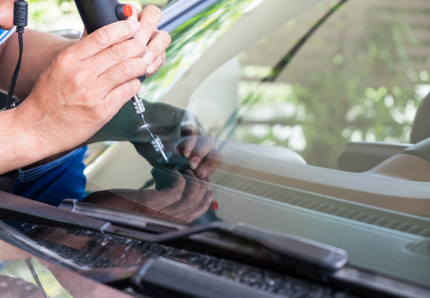 Glazier using tools repairing to fix crack windshield - Fotoğraf, Görsel