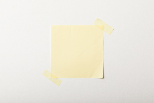 papel blanco amarillo con cinta adhesiva sobre fondo blanco
 - Foto, imagen