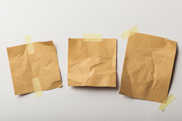 brown crumpled papers with sticky tape on white background - Photo, Image