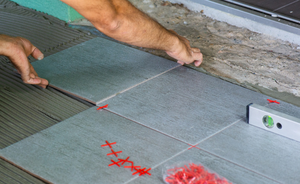 Operaio installazione di piastrelle del pavimento a casa
 - Foto, immagini