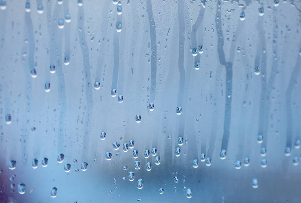 Tropfen Kondenswasser auf das Glas tropfen. Hintergrund der natürlichen Wasseransammlung durch Fensterkondensation - Foto, Bild