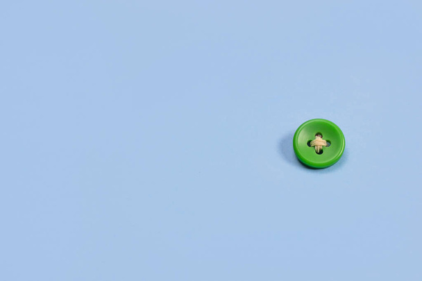Big green button on a blue background - Φωτογραφία, εικόνα