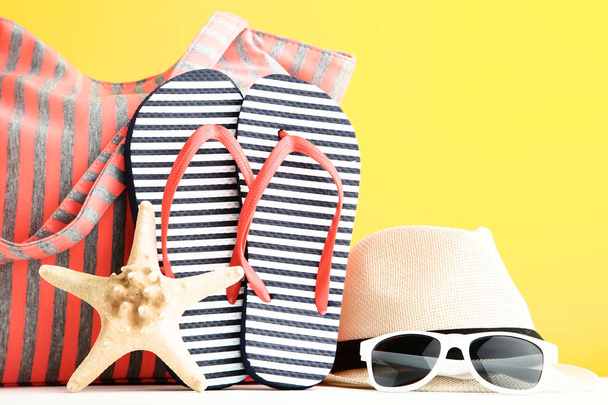 Summer bag with flip flops and starfish on yellow background - Foto, Bild
