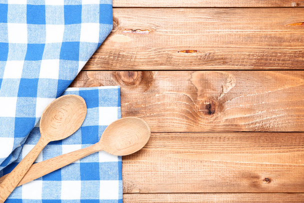 Wooden cutlery with blue napkin on brown table - Foto, Bild