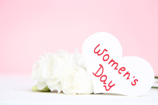 Text Women's Day with eustoma flowers on pink background - Foto, immagini