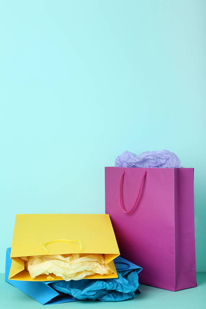 Colorful paper shopping bags on mint background - Photo, image