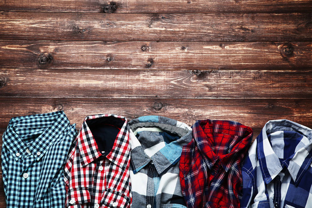 Colorful shirts on brown wooden table - Foto, Imagem