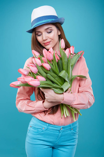 Young beautiful woman studio portrait with tulip flowers - Фото, изображение