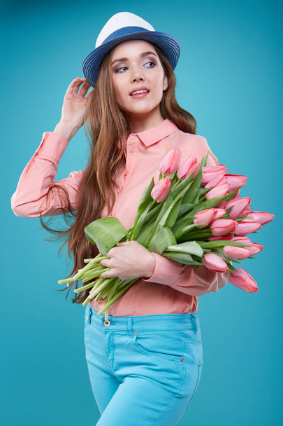 Young beautiful woman studio portrait with tulip flowers - 写真・画像